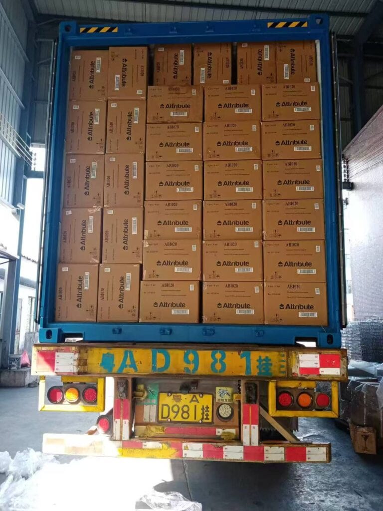 Un container pieno di scatole contenenti utensili da cucina in acciaio inossidabile in un magazzino.